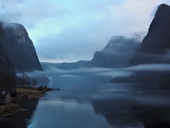 Scenic view of lake by mountains against sky