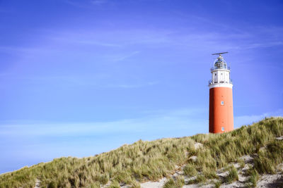 Lighthouse amidst buildings against sky