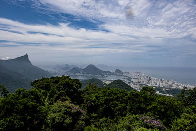 Scenic view of city among mountains against sky