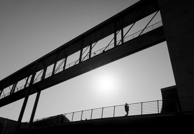 Low angle view of silhouette bridge against clear sky