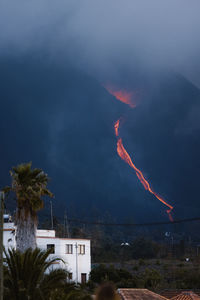 Hot lava and magma pouring out of the crater with black plumes of smoke. cumbre vieja volcanic eruption in la palma canary islands, spain, 2021