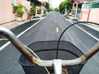 Cropped image of bicycle on road amidst houses in city