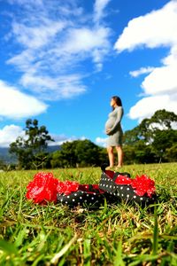 Close-up of woman with mushroom on field against sky