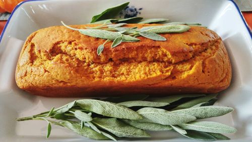 High angle view of pumpkin bread by sages in plate on table