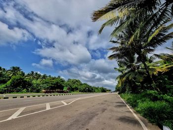 Road by trees against sky