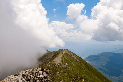 Low angle view of mountain against cloudy sky