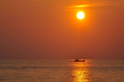 Scenic view of sea against orange sky