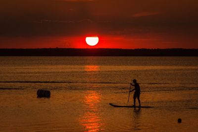 Silhouette of people on beach at sunset