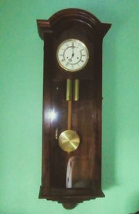 Close-up of illuminated clock hanging on wood