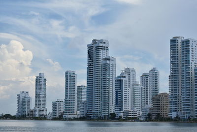 Sea by cityscape against sky