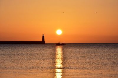 Scenic view of sea against orange sky