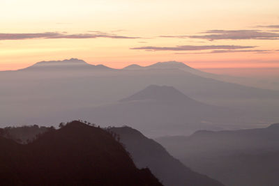 Scenic view of mountains against sky at sunset