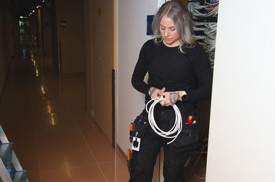 Female electrician holding cable