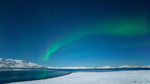 Scenic view of snowcapped mountains against blue sky at night