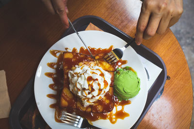 High angle view of person holding ice cream in plate