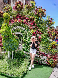 Full length of woman standing against plants