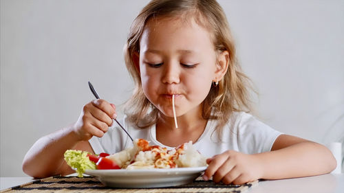 Cute girl eating food at home