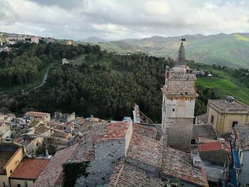 Aerial view of cityscape against cloudy sky