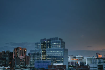 Modern buildings against blue sky at dusk
