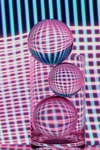 Close-up of crystal balls in glass against illuminated lights