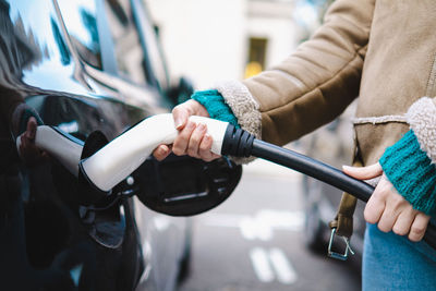 Woman charging electric car at station