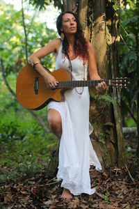 Portrait of young woman playing guitar