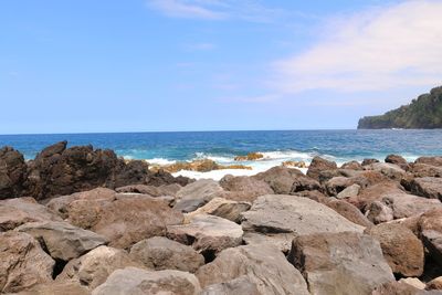 Scenic view of rocks on beach against sky