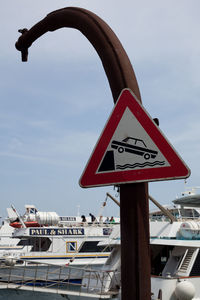 Low angle view of sign board against sky