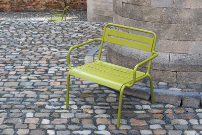 High angle view of empty chairs against brick wall