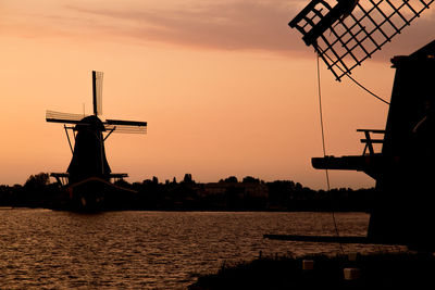 Silhouette traditional windmill against sky during sunset