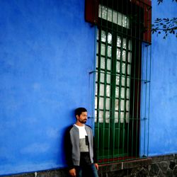 Portrait of boy standing against blue sky