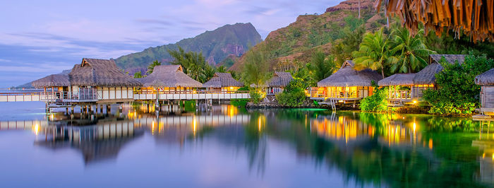 Scenic view of lake and houses against sky