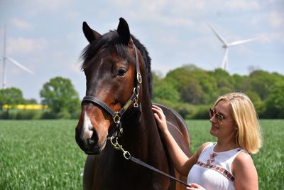 Woman riding horse on field