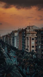 High angle view of street amidst buildings against sky during sunset