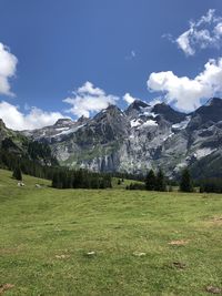 Scenic view of field and mountains against sky