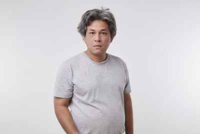 Portrait of mid adult man standing against white background