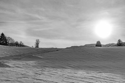Scenic view of sand dunes against sky during winter