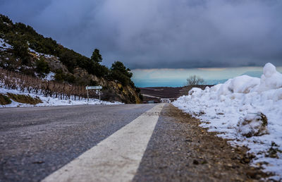 Empty road along snow covered landscape