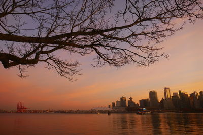 Scenic view of sea and buildings against sky at sunset