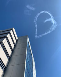 Low angle view of modern building against blue sky