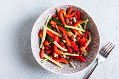 Close up of vegetarian salad of red beans, cucumber and bell pepper in a bowl on the table top view