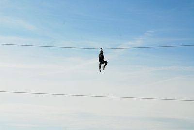 Low angle view of man on tyrolean rope