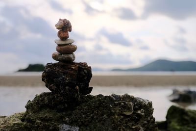 Stack of stones on beach against sky