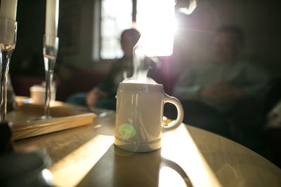 Coffee on table with people in background at home