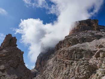 Low angle view of rocky mountains against sky