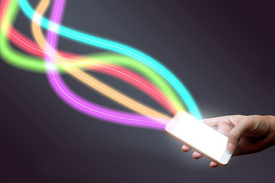 Close-up of hand holding illuminated light over black background