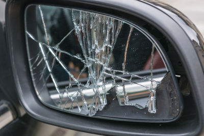 Close-up of broken side-view mirror of car