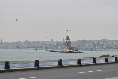 Sailboats in sea against buildings in city