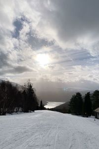 Scenic view of snow covered field against sky