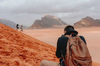 Rear view of man on land against mountains